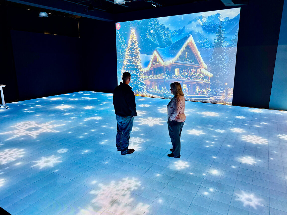 Winter cabin scene on the projection wall with snowflakes across the LED floor